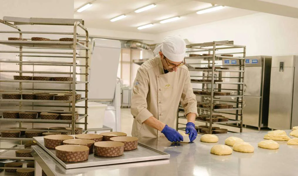 Un pasticcere Tenerità forma i panettoni sul banco del laboratorio